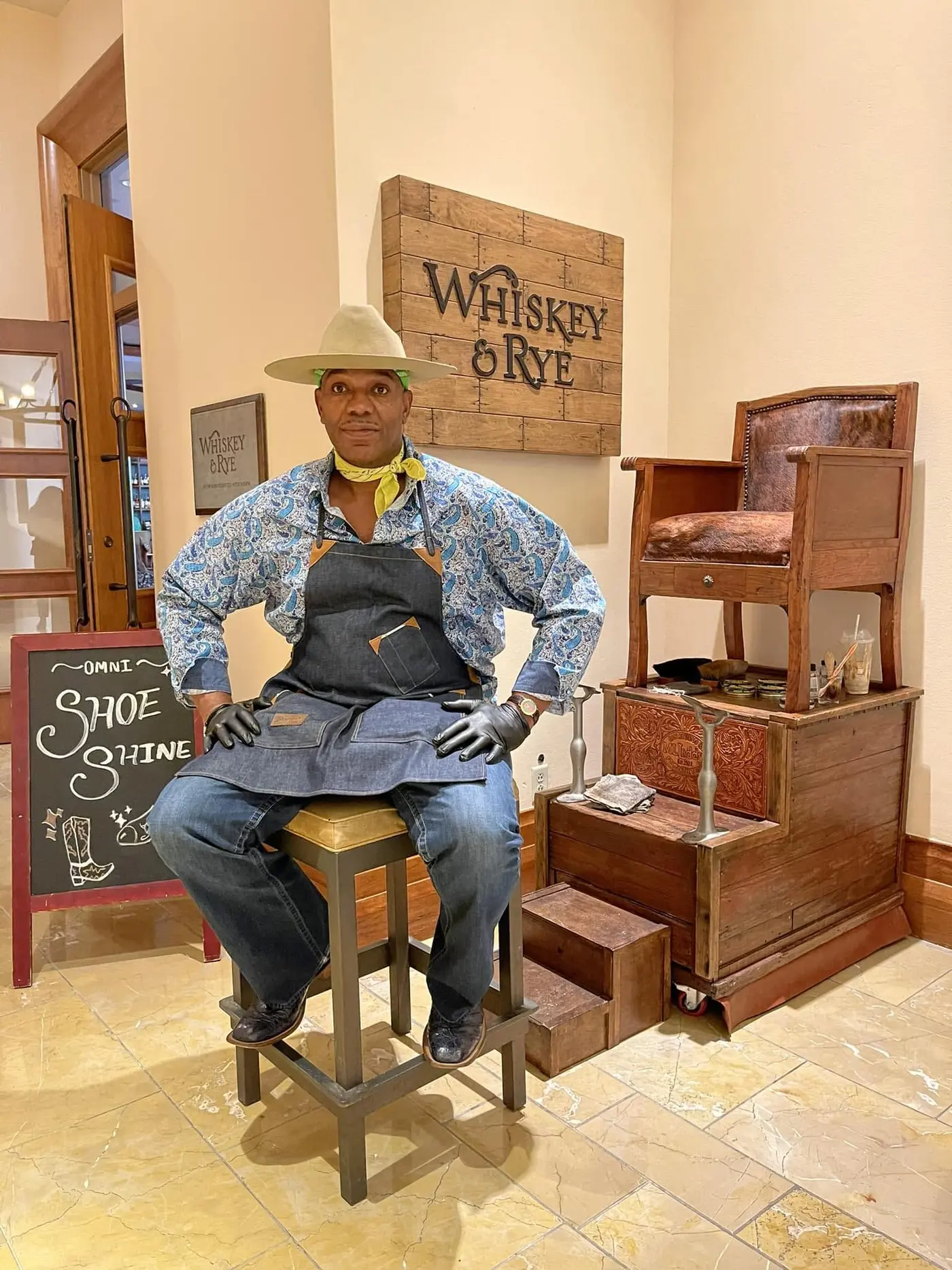L.A.'s Boot and Shoe Shine craftsman beside a traditional shine chair
